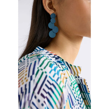 Pair of blue circular earrings on a light gray background.