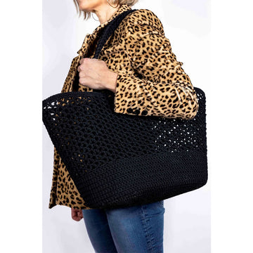 A woven black basket bag against a white background.
