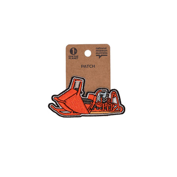 Red snowmobile patch on a brown card with 'National Museum of Australia' branding.