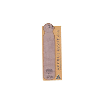 Wooden bookmark shaped like a seal pup with packaging on a white background.