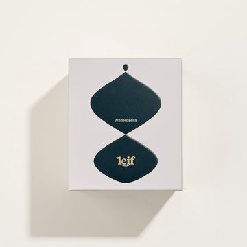 Front view of a glass candle in pink with the text 'Wild Rosella Bougie Parfumee 280g' written on the front and the Leif logo.