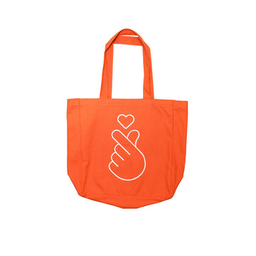 Orange tote bag with a white hand gesture and heart design on a white background.
