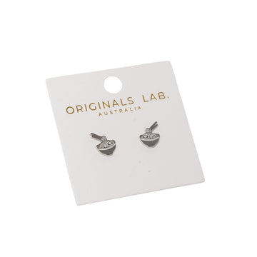 Pair of earrings shaped like noodle bowls on a 'Originals Lab.' branded card against a white background.