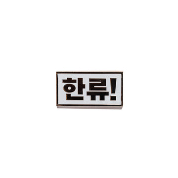 A metal magnet with Korean characters.