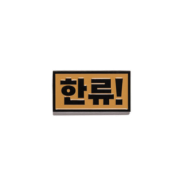 A metal magnet with Korean characters.