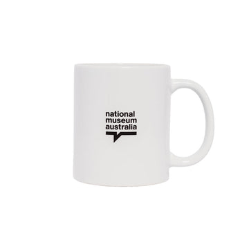 A white ceramic mug with a line drawing of a hand making a heart symbol.