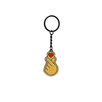 Keychain with a gold hand holding a red heart on a white background.