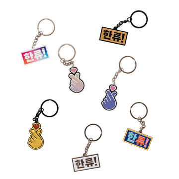 Keychain with a gold hand holding a red heart on a white background.