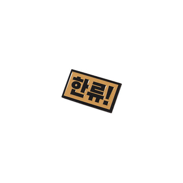 Rectangular metal pin with Korean text on a white background.
