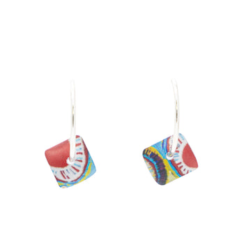 A pair of silver hoop earrings with little squares printed with artwork by Murdie Morris hanging off the hoops.