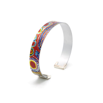 A bangle standing up and printed with artwork by Murdie Morris.