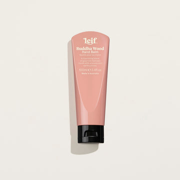 A small pink tube of handcream with the heading 'Buddha Wood Hand Balm' written on the front.