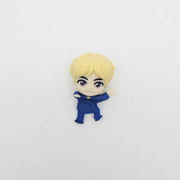 Small figurine of a character with blonde hair and a blue outfit on a white background.