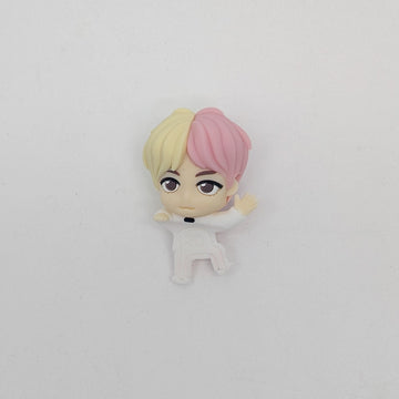 A small figurine with pink and blonde hair wearing a white outfit.