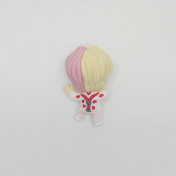 A small figurine with pink and blonde hair wearing a white outfit.