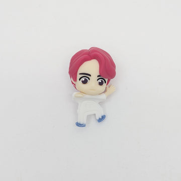 Small figurine with pink hair and white outfit on a light gray background.