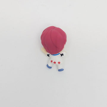 Small figurine with pink hair and white outfit on a light gray background.