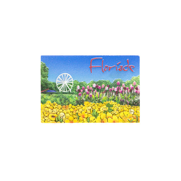 A rectangle magnet with an embossed design of a Ferris wheel, pink tulips in a green field and yellow flowers at the front. The text 'Floriade' is in the top right corner.