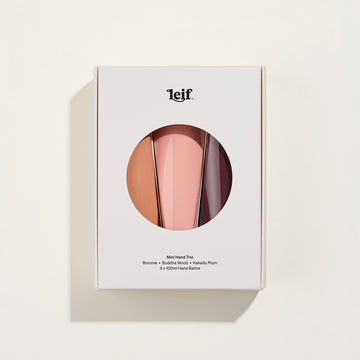 A white box with a circle cut out showing three hand cream bottles inside in different shades of brown.