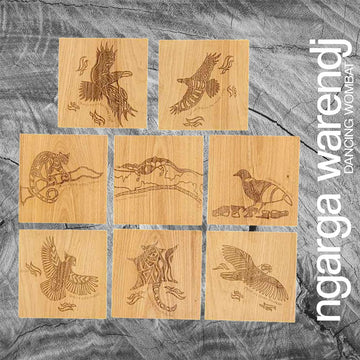 A set of eight square wooden coasters each etched with a different animal or bird.