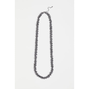 A gunmetal necklace against a light grey background.