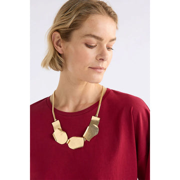 A silver necklace with five overlapping shapes as the long pendant.