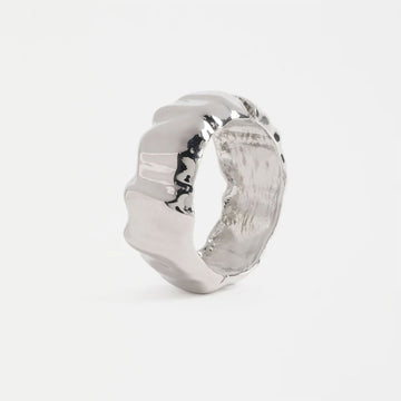 Silver bangle with a textured design on a white background.