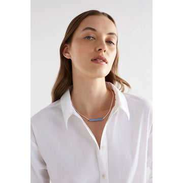 A chain necklace with a long round teal bead in the centre.