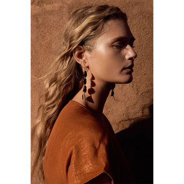 Gold earrings with layered scallop designs on a white background.