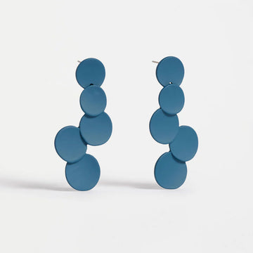 Pair of blue circular earrings on a light gray background.