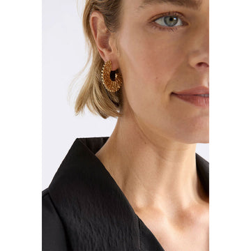 Gold hoop earrings on a light beige background.