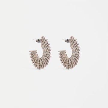 Pair of silver hoop earrings on a light gray background.