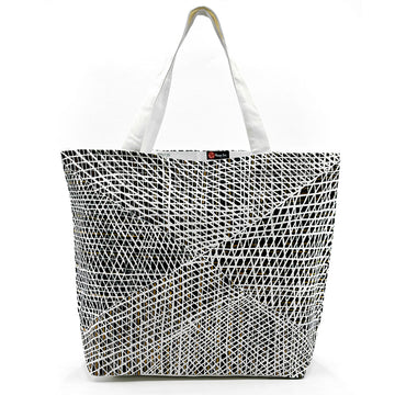 A large tote bag printed with artwork by Paulina Puruntatameri in black and white.