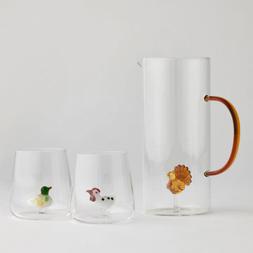 Set of two glass cups and a jug with a glass bird inside each on a white background.