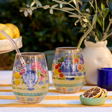 Two decorative glass tumblers with floral and fruit design on a white background.
