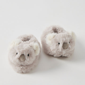 A pair of baby booties with koala heads on them.