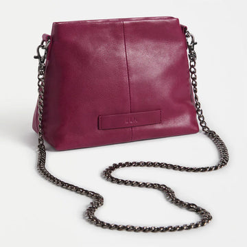 Maroon handbag with chain strap on a white background.
