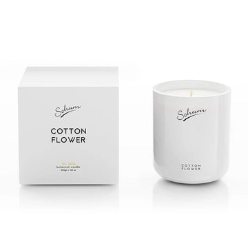 A white candle next to a matching white box with the text 'Sohum Cotton Flower' written on both items.
