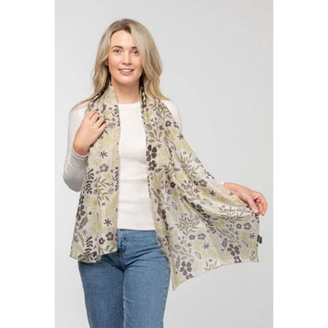 A silk scarf printed with leaves and flowers in a natural colour scheme.