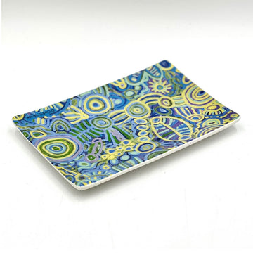 A ceramic rectangle tray printed with artwork by Cedric Varcoe in blue and yellow.