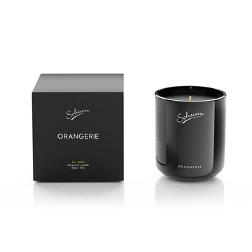 A black candle next to a matching black box with the text 'Sohum Orangerie' written on both items.
