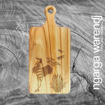 Wooden cutting board with laser-engraved design on a gray stone surface, featuring the brand 'ngarga warendj'.