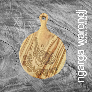 A round wooden board with an engraving of a long neck turtle.