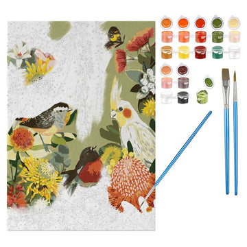 A paint by numbers on a canvas half painted with a design of birds and flowers. There are three paint brushes and small paint pots next to the canvas.