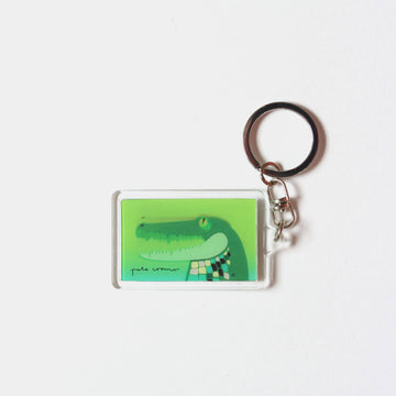 A rectangle keyring with a moving image of a crocodile against a green background.