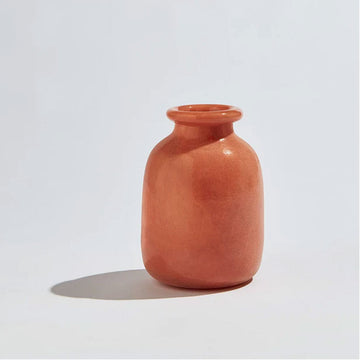 A tall round vase in the shape of a jar with a smaller opening in an orange clay colour.