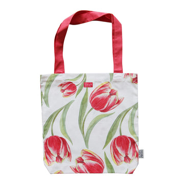 A tote bag with red straps and illustrated with red tulips.