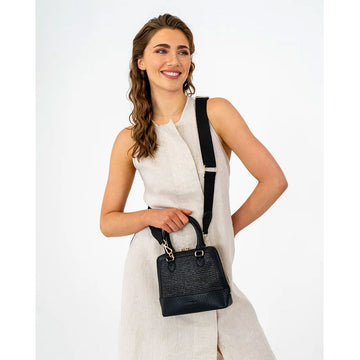 Front view of a handbag in black with a woven design on the front with a double top zipper and multiple straps.