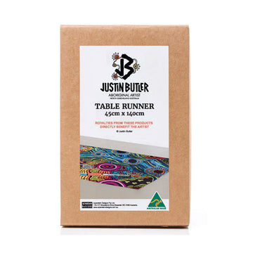 A brown box with a white label on the front with the text 'Justin Butler Table Runner' and a photo of the table runner.