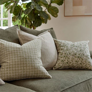 A square cushion printed with a diamond print in light green.